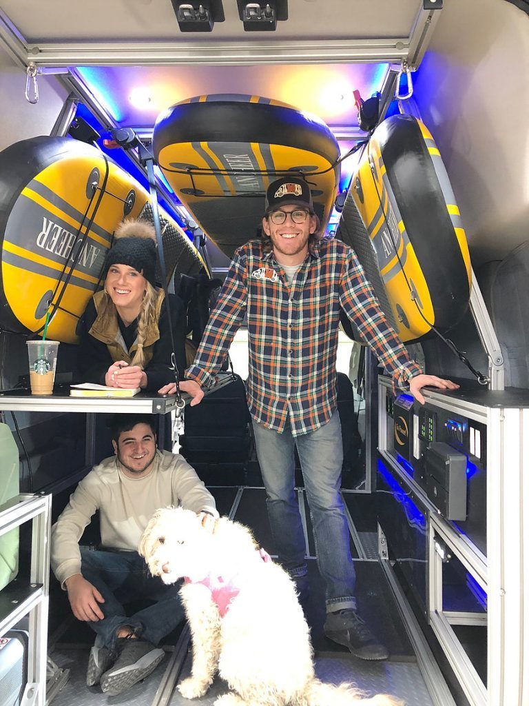 Van DO It team in the van with a small pup and some inflated SUP's
