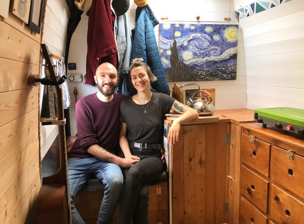 vincentvanlife Rose and Sen sat on a chair in their camper conversion