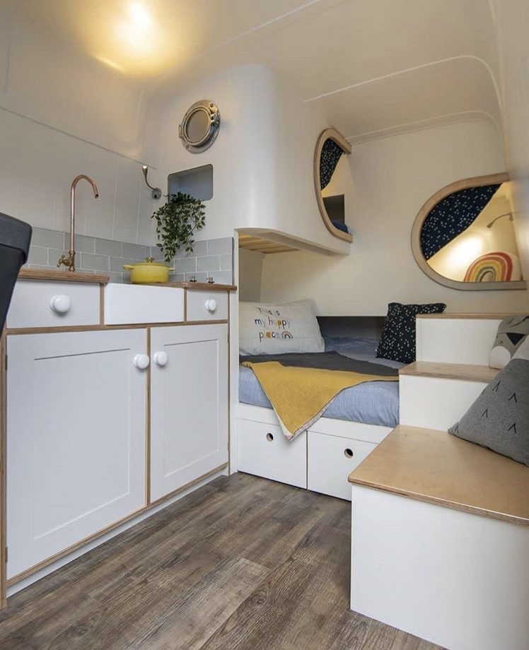 White van interior with sleeping pods at back.