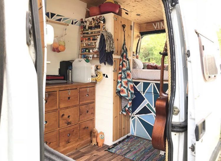 Wooden van interior with blue patterened drawers.