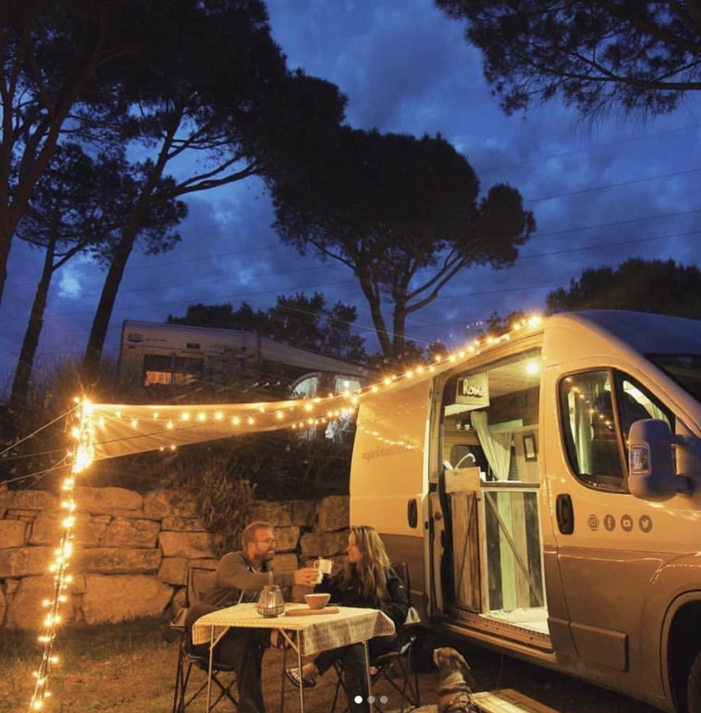 Couple outside their van at night time.