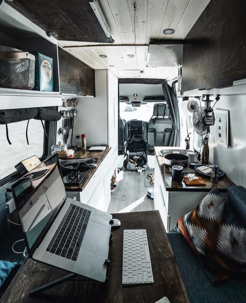 Work station with laptop inside camper van.