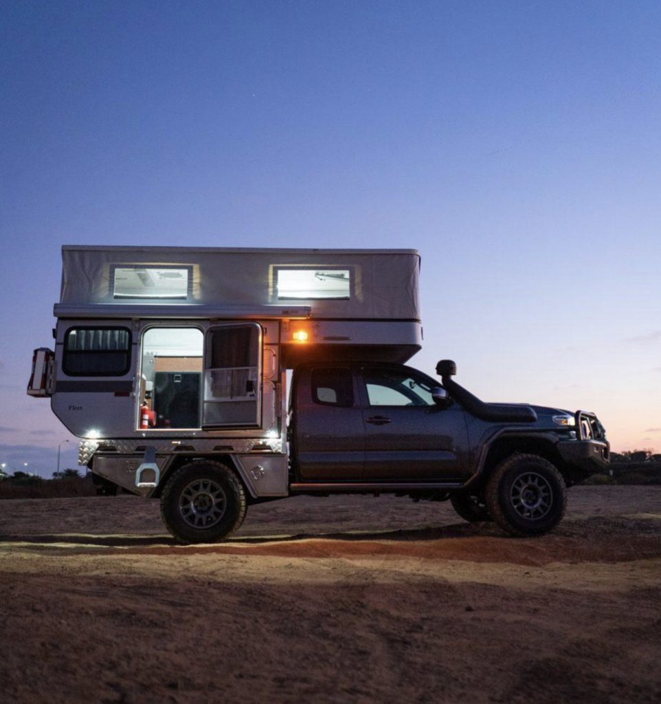 Best Motorhomes - Four Wheel Camper at night with roof popped