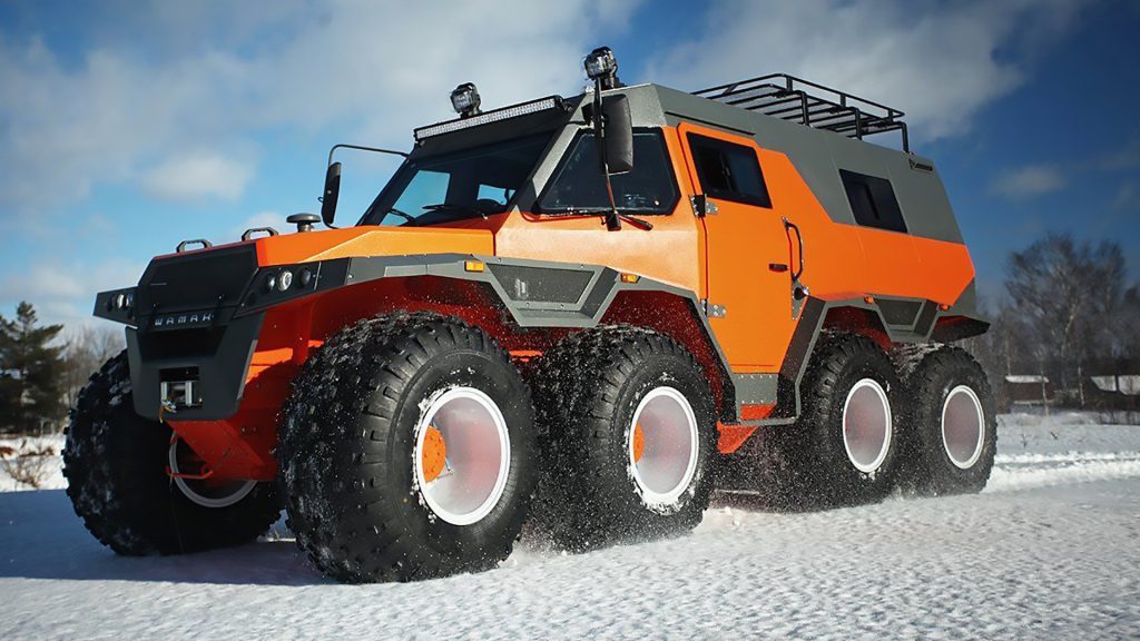 Avtoros Shaman on the snow. A bright orange monster camper with eight ginormous wheels!