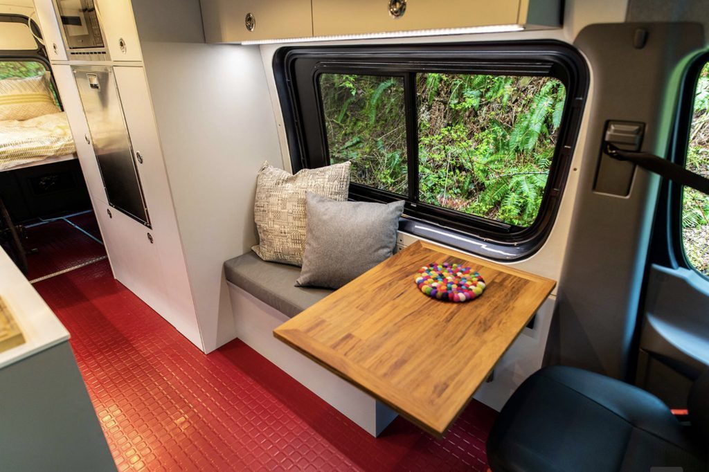 Levi interior- red floor, white cabinetry, wooden table top.