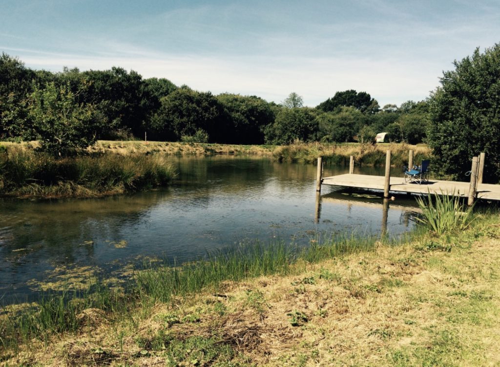 Best Campervan Campsites UK - Pleasant stream farm camping lake with jeti and van in background