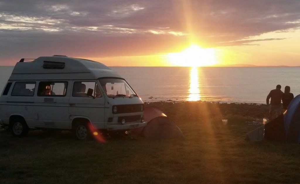 VW overlooking water at sunset