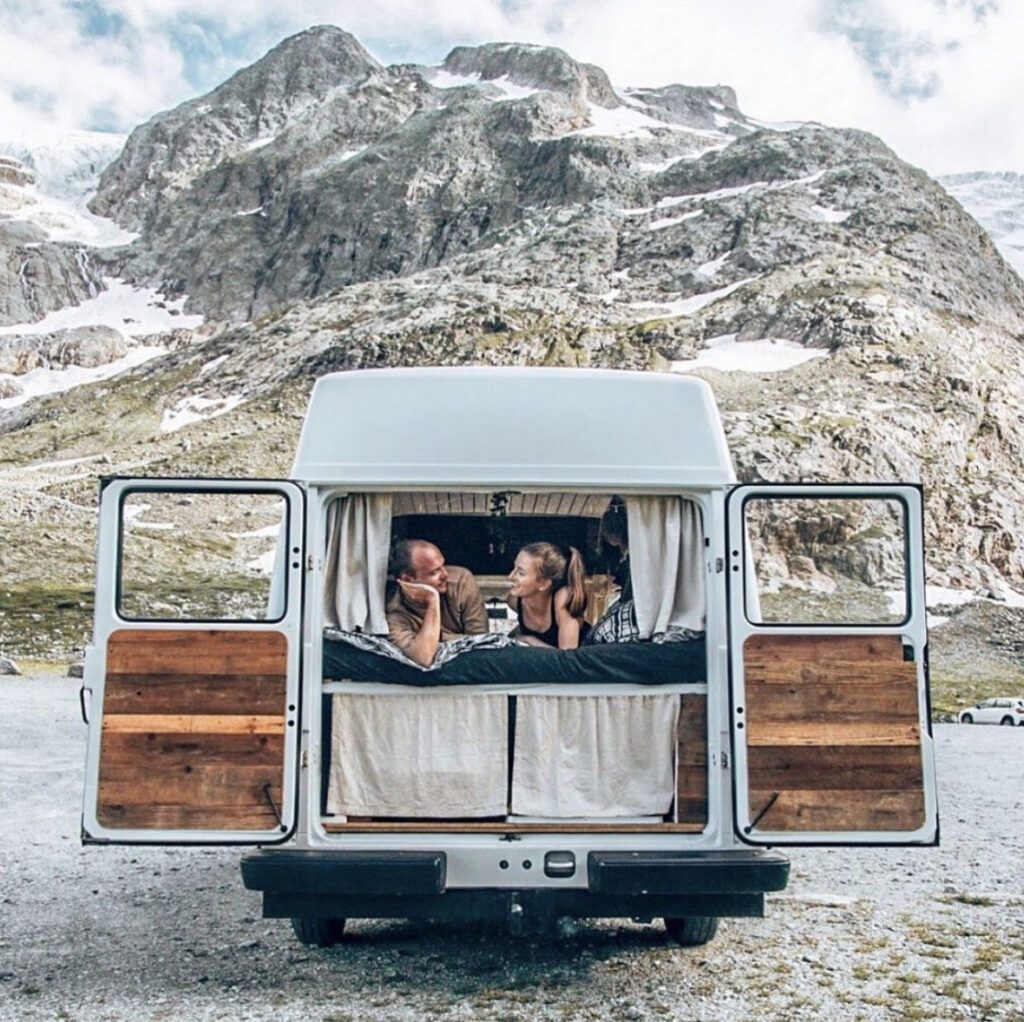 Two people in a van infront of a mountain