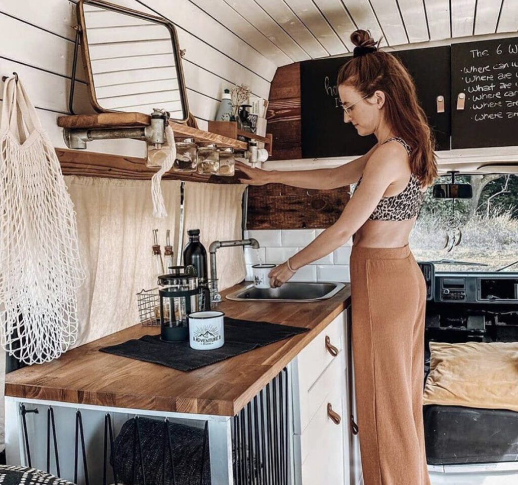 Small RV - woman using tap inside camper