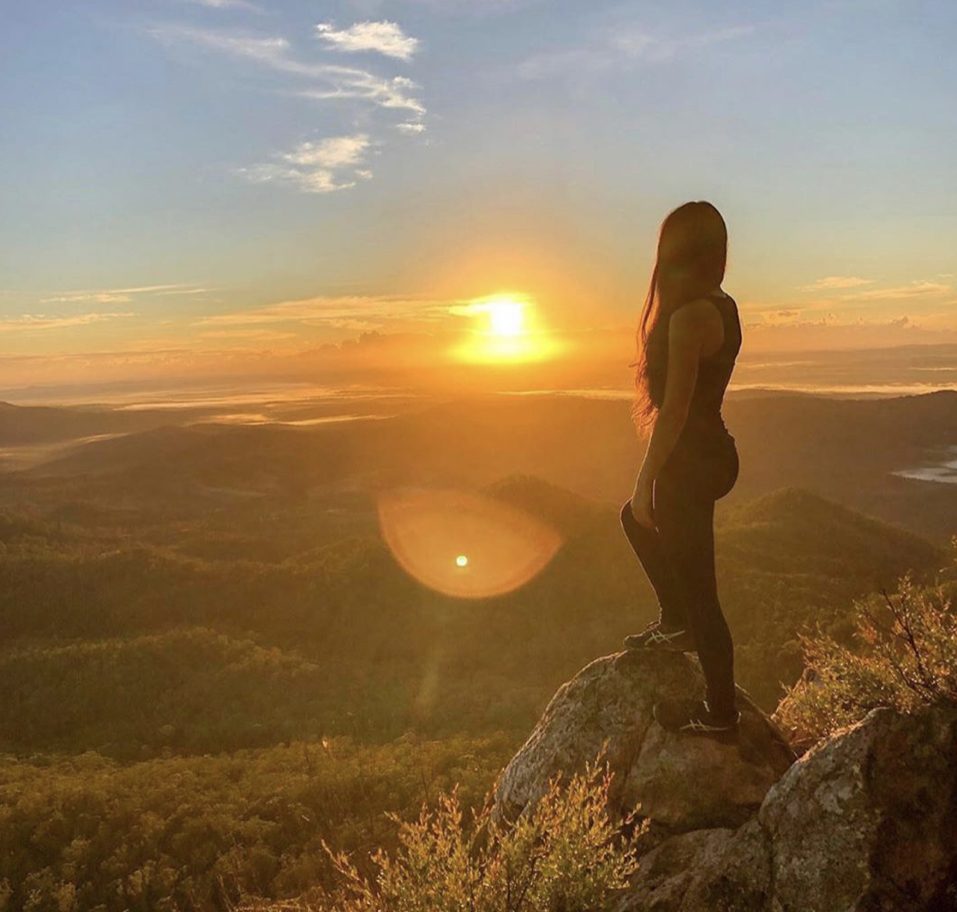 Woman in the sun at top of mountain