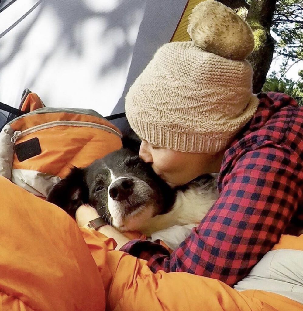 Person snuggling their dog in a tent