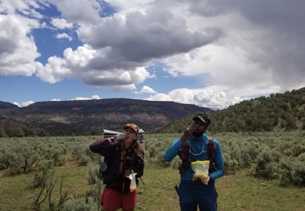 What to bring on a hike: man and woman stopping for a snack on a hike