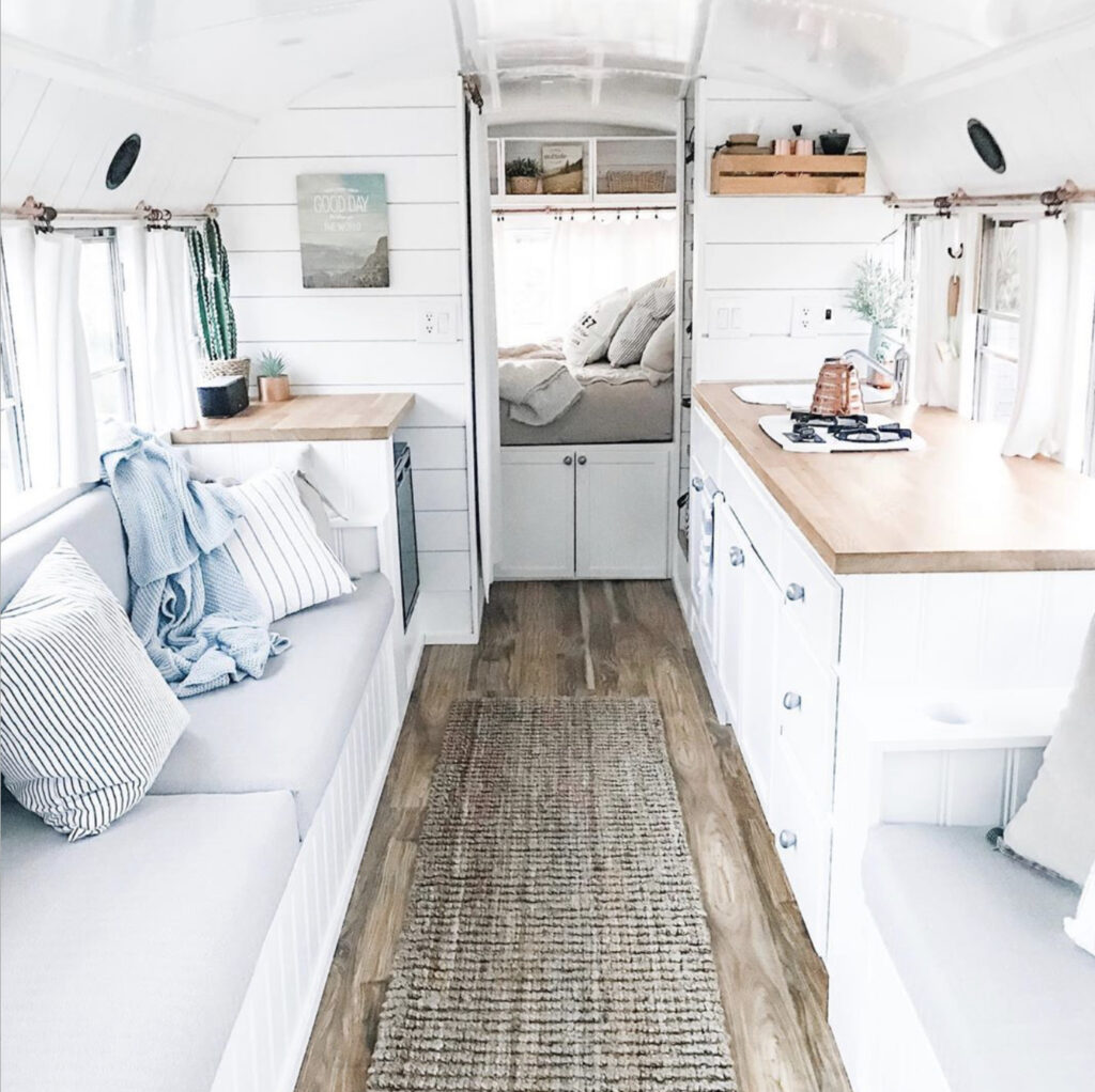 All white bus with white kitchen, walls and ceiling.