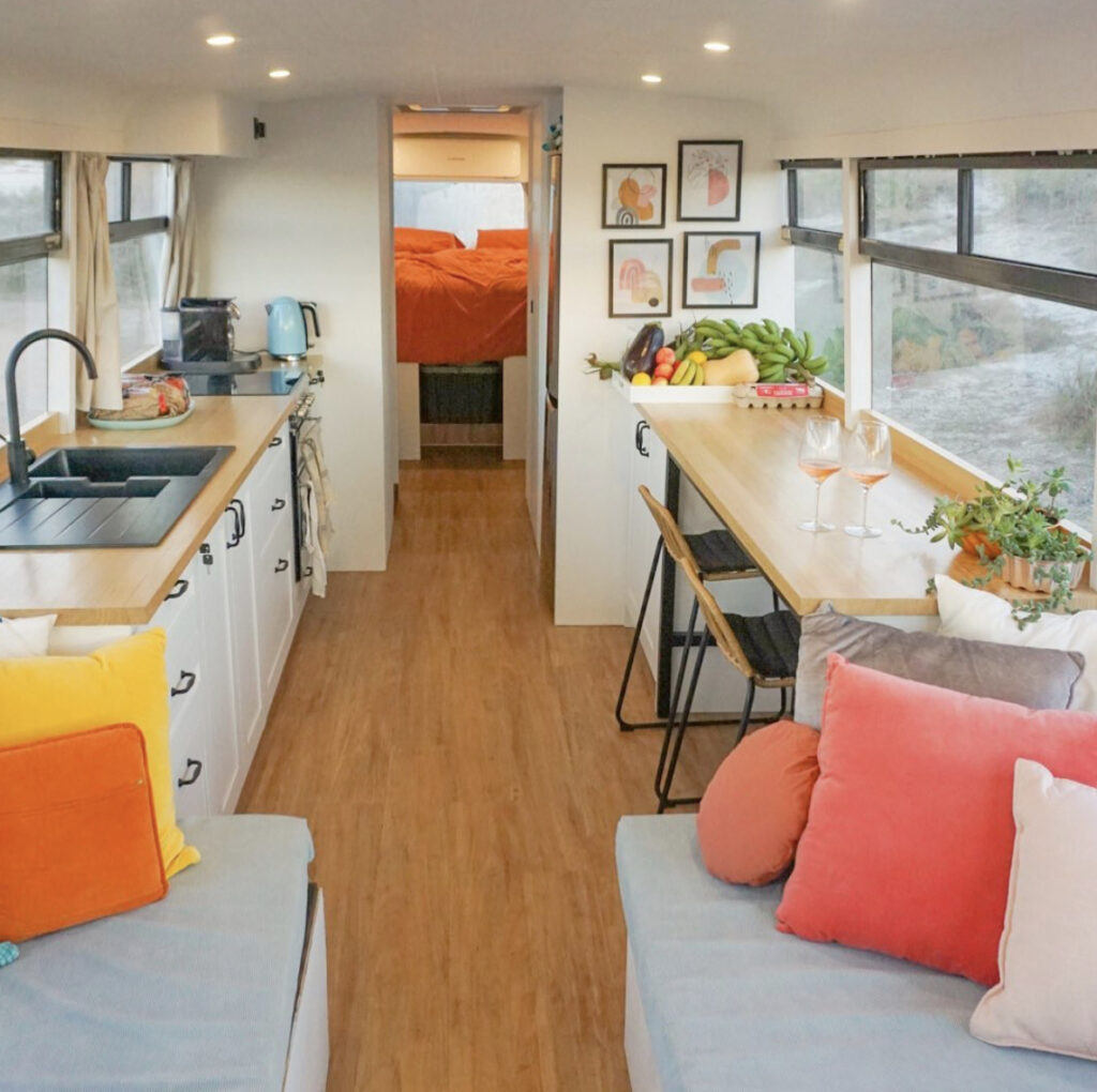 Modern and stylish bus, white walls and colourful cushion accents throughout