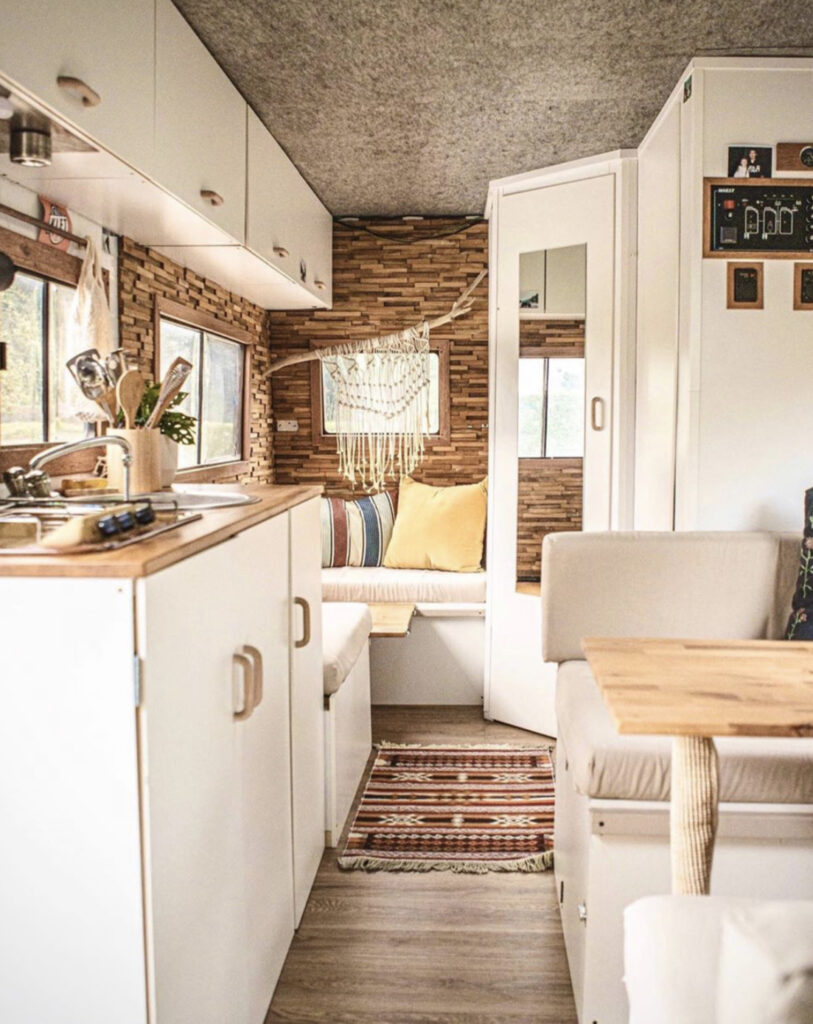 Camper conversion with white kitchen and lots of seating space