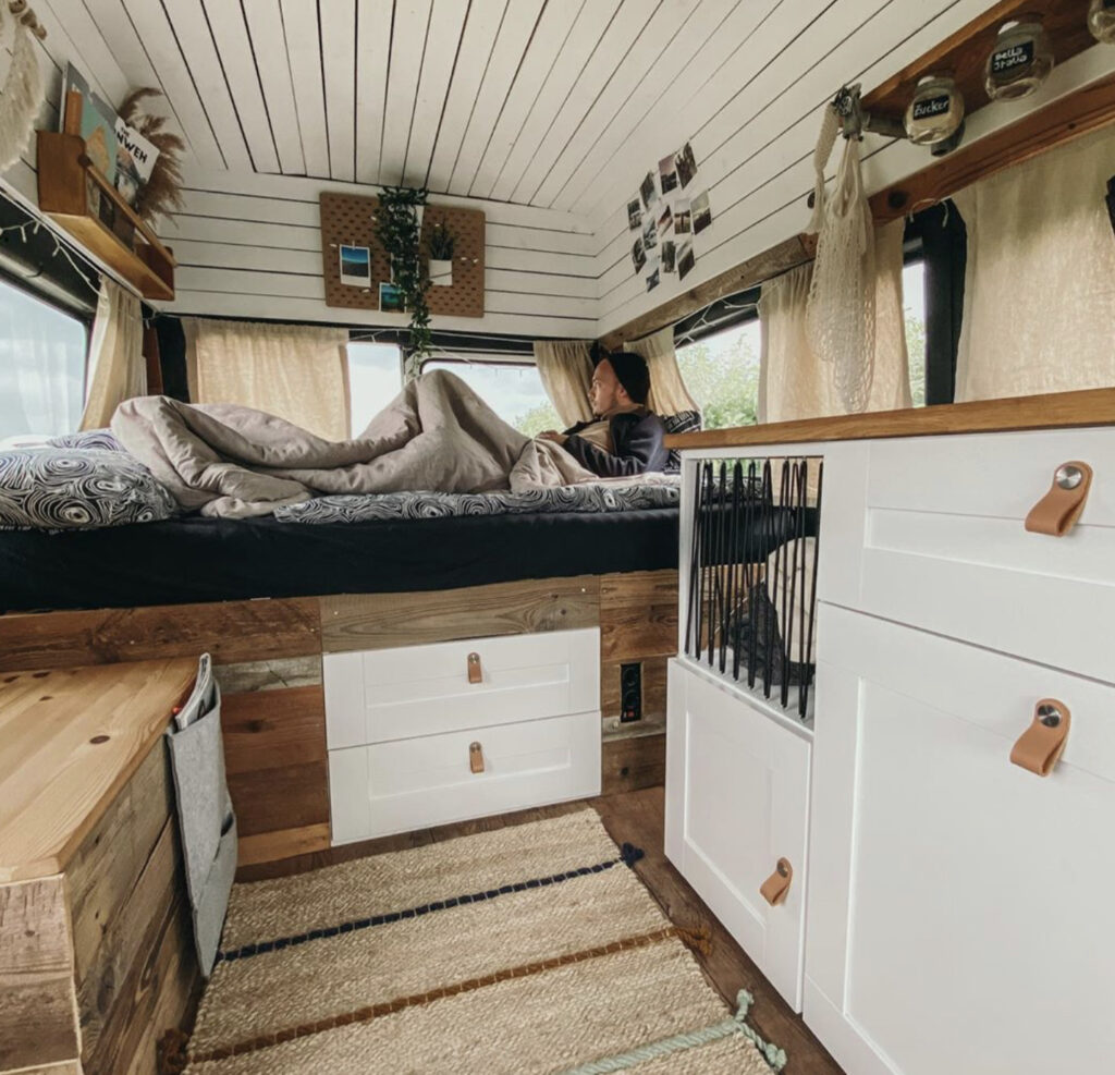 White interior with fixed bed and recycled wooden cabinets