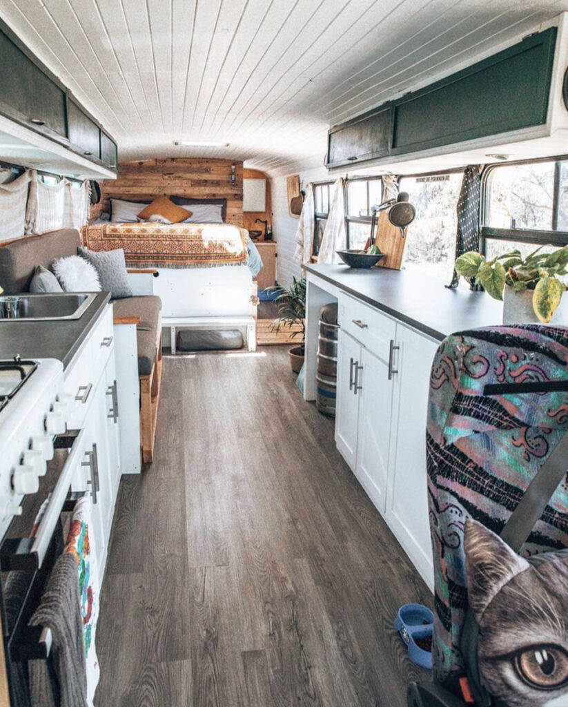 Open plan bus conversion with kitchen sofa and bed